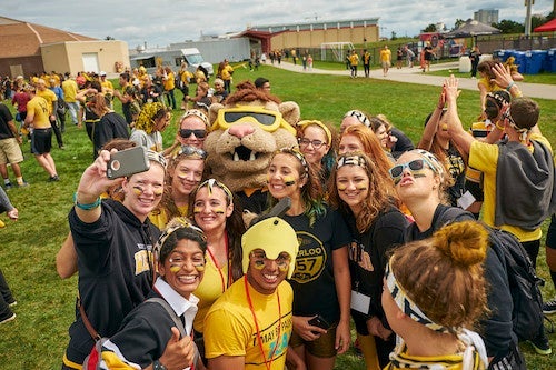 King Warrior surrounded by students with their faces painted.