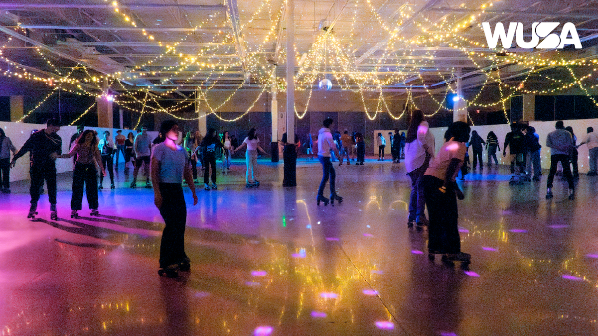 People rollerskating at a rink.