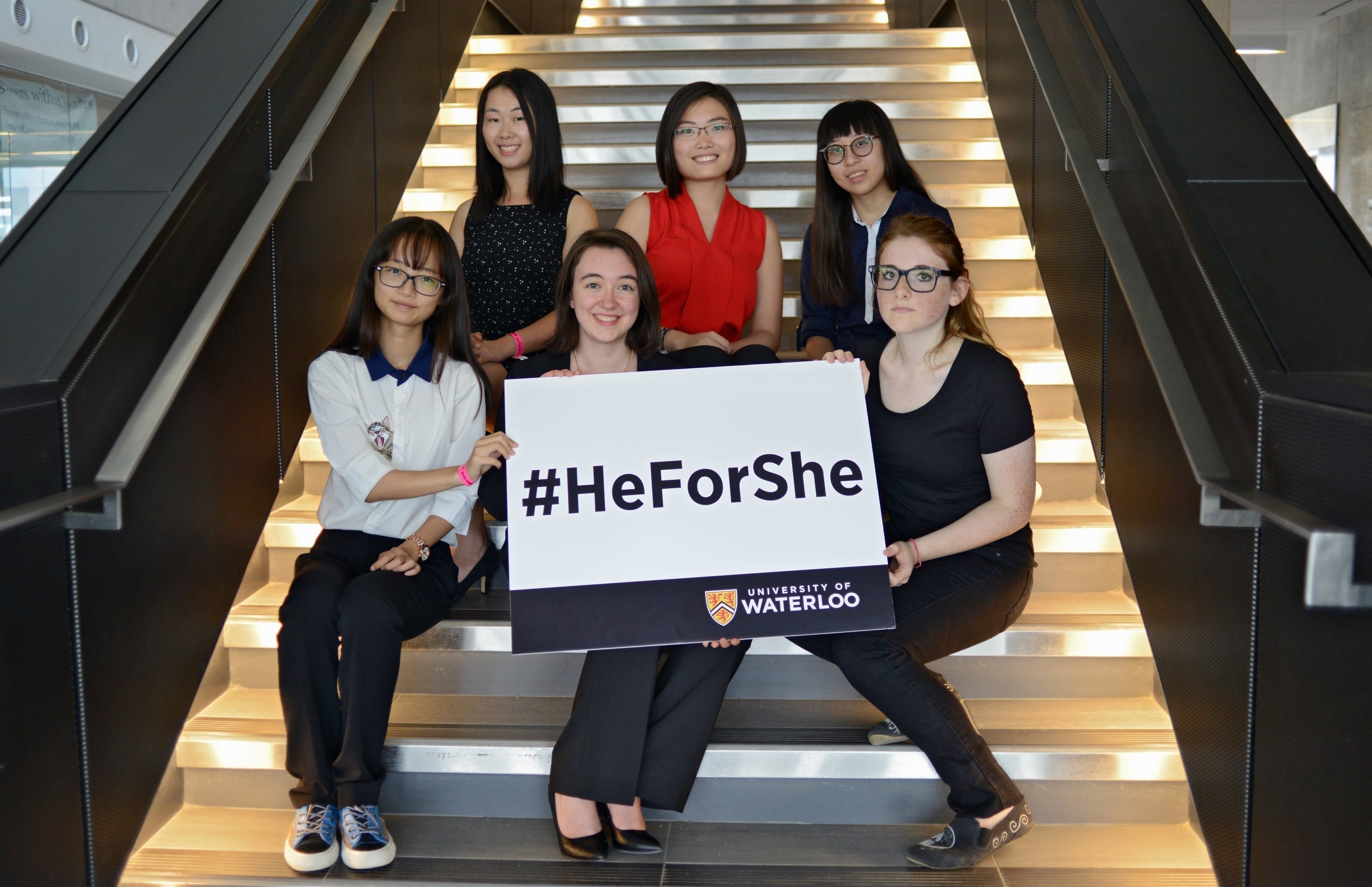 The six HeForShe scholarship winners pose with a sign that says #HeForShe.