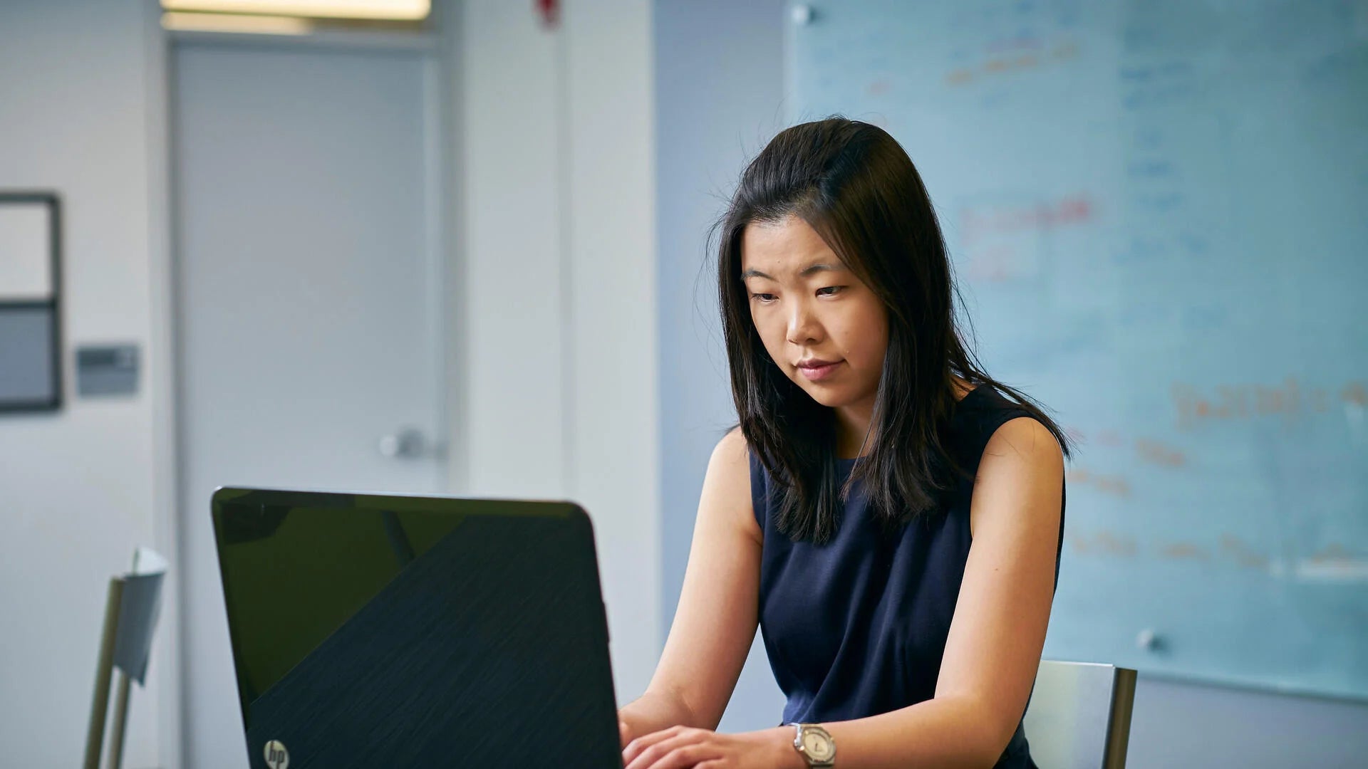 A young woman works on a laptop.