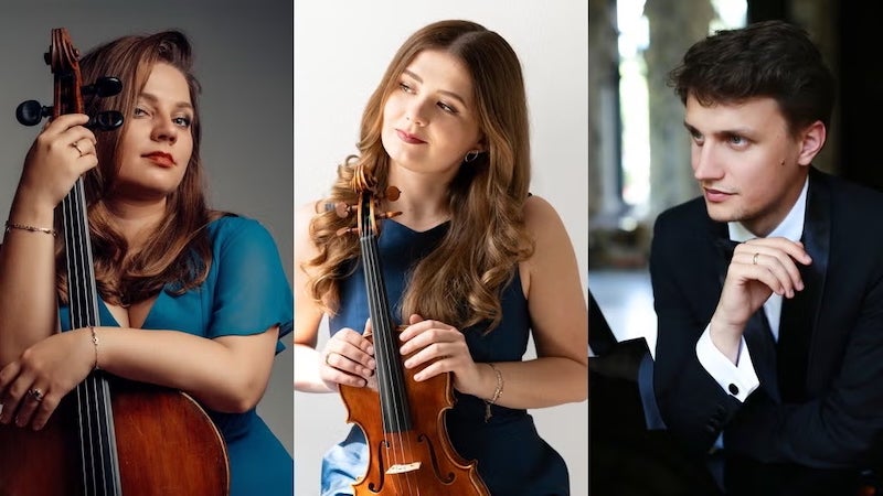 The three members of the Cuore Piano Trio - two women holding a cello and violin, and the male pianist.