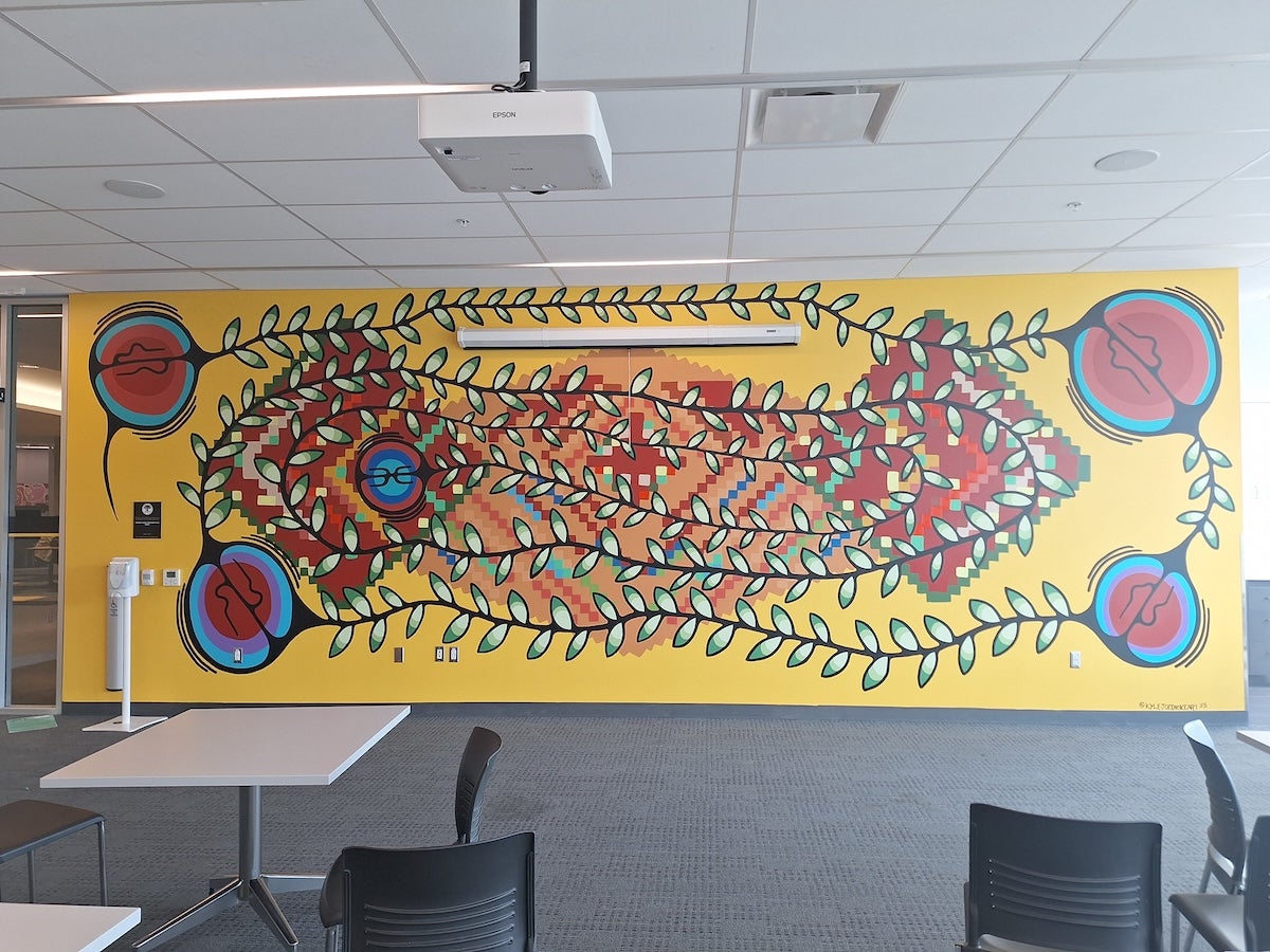 The mural by Indigenous artist Kyle Joedicke on the wall in the SLC Grad Lounge.