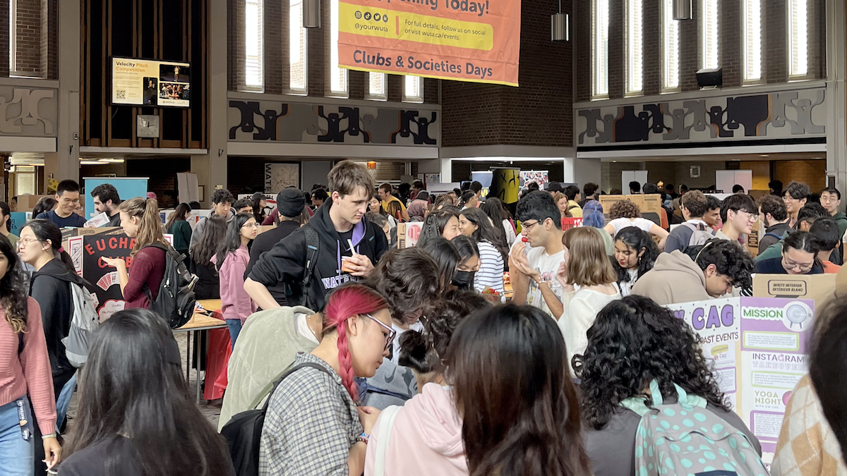 A packed Great Hall with booths and students.