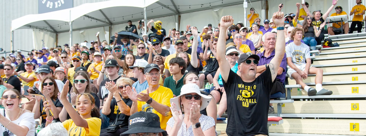 Homecoming sports enthusiasts cheer in the stands.