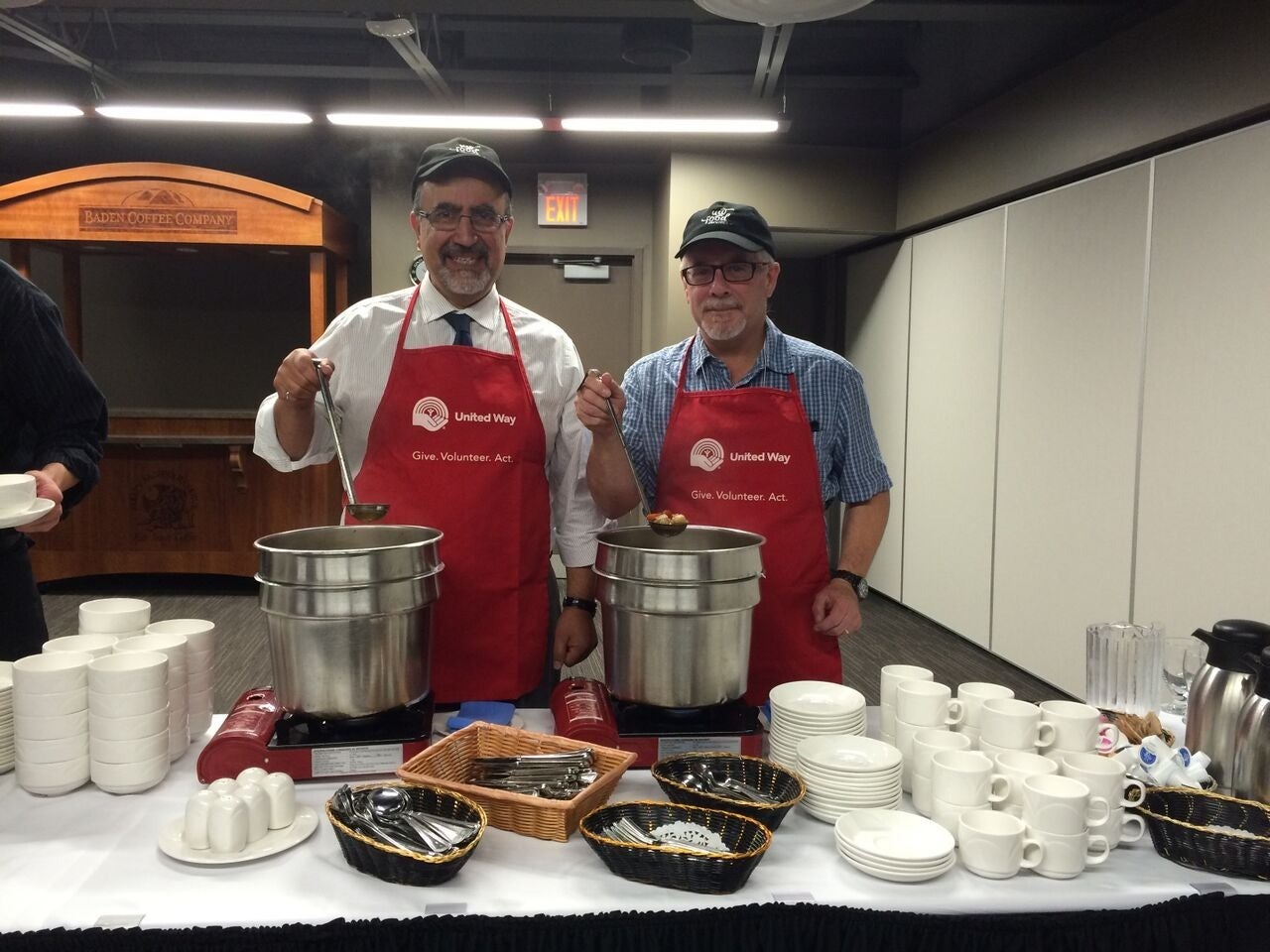 Feridun Hamdullahpur and Douglas Peers serve food.