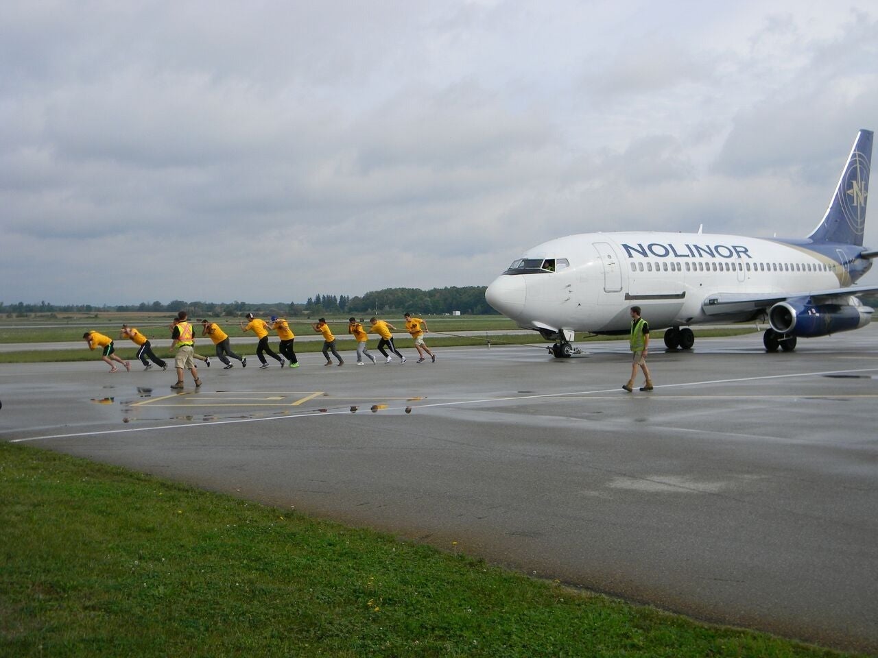 Waterloo volunteers pull a 737 jetliner across the tarmac.