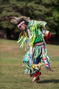 An Indigenous performer in traditional garb.