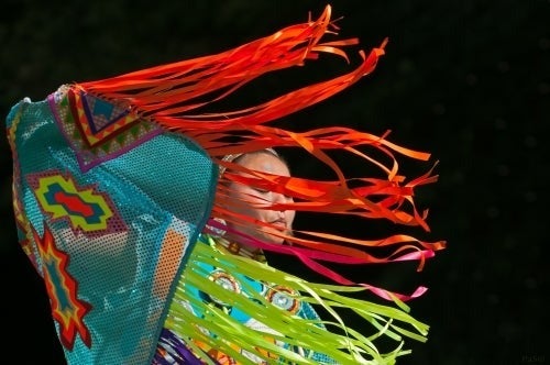 A woman in traditional indigenous garb performs.