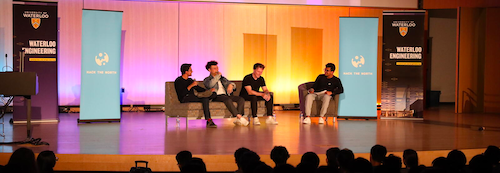 Hack the North alumni on stage speaking during a panel discussion.