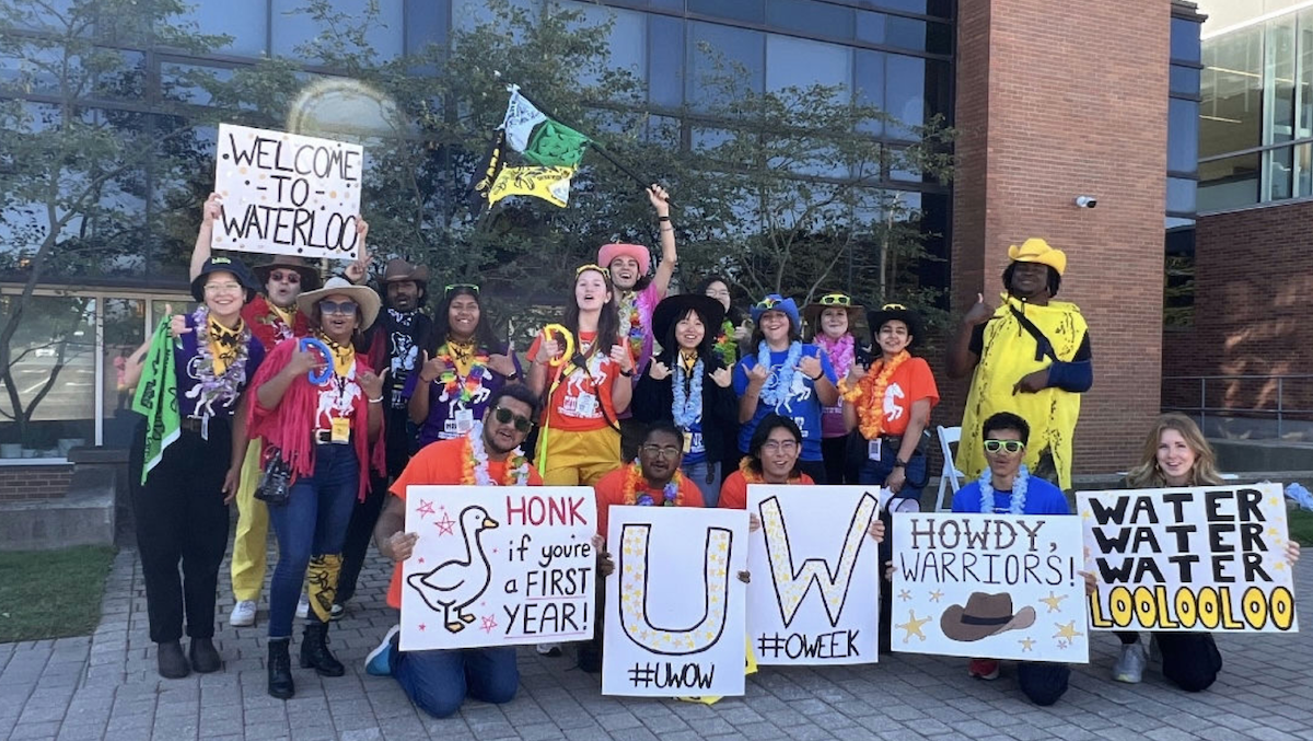 Volunteers dressed with flags and signs to welcome new students to Waterloo.