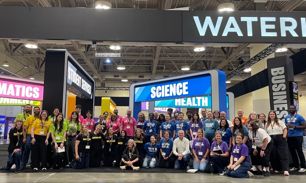 University of Waterloo staff and student volunteers pose together at the Ontario Universities’ Fair exhibition booth.