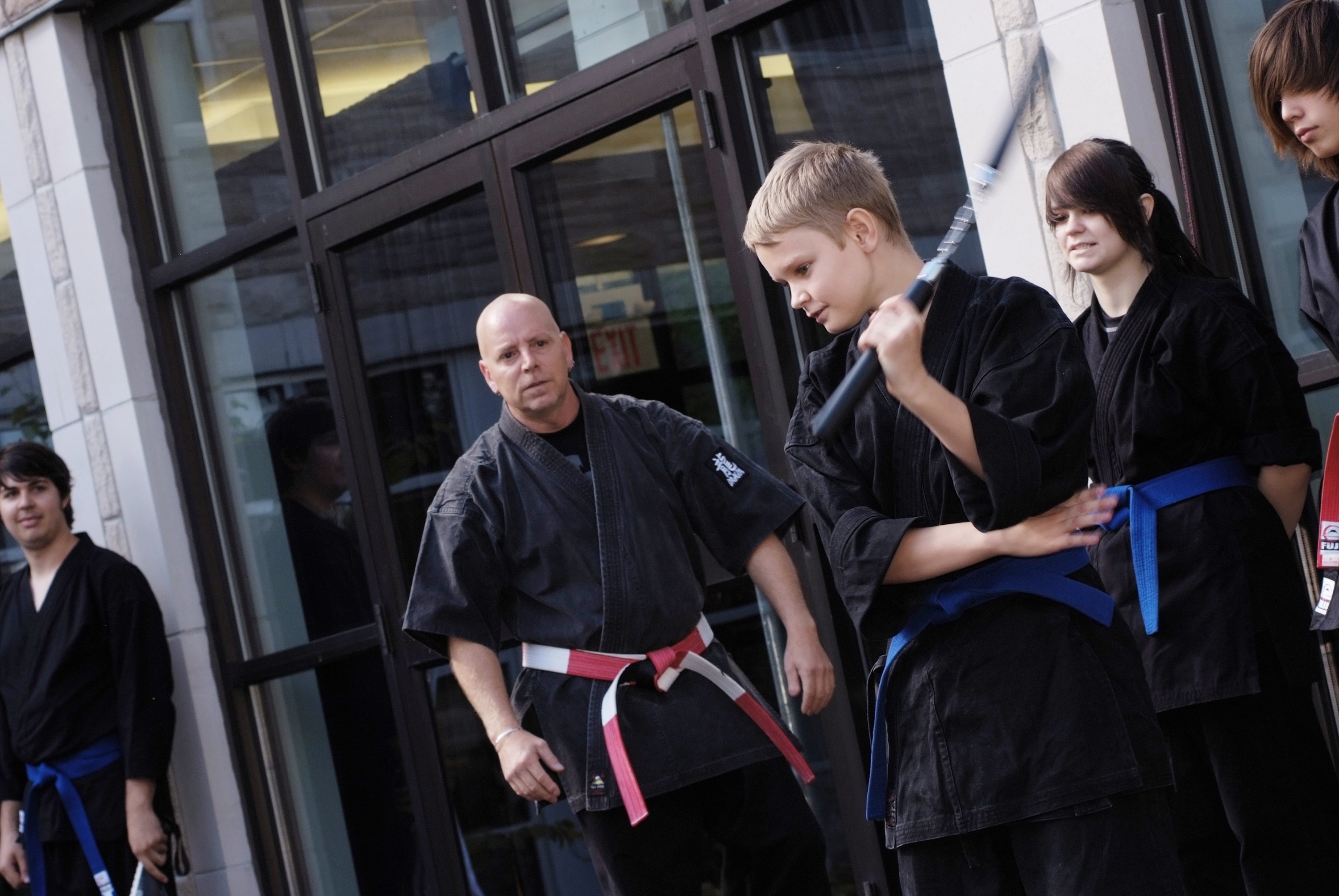 A young student performs a routine with nunchaku.