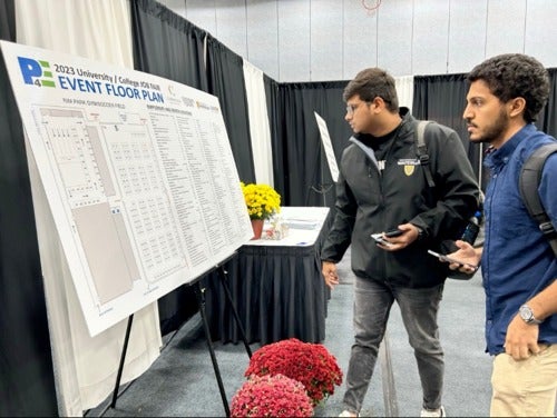 Two students look at the P4E Job Fair floor plan.