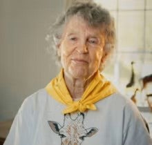 Photo of Anne Dagg with a yellow scarf and giraffe shirt