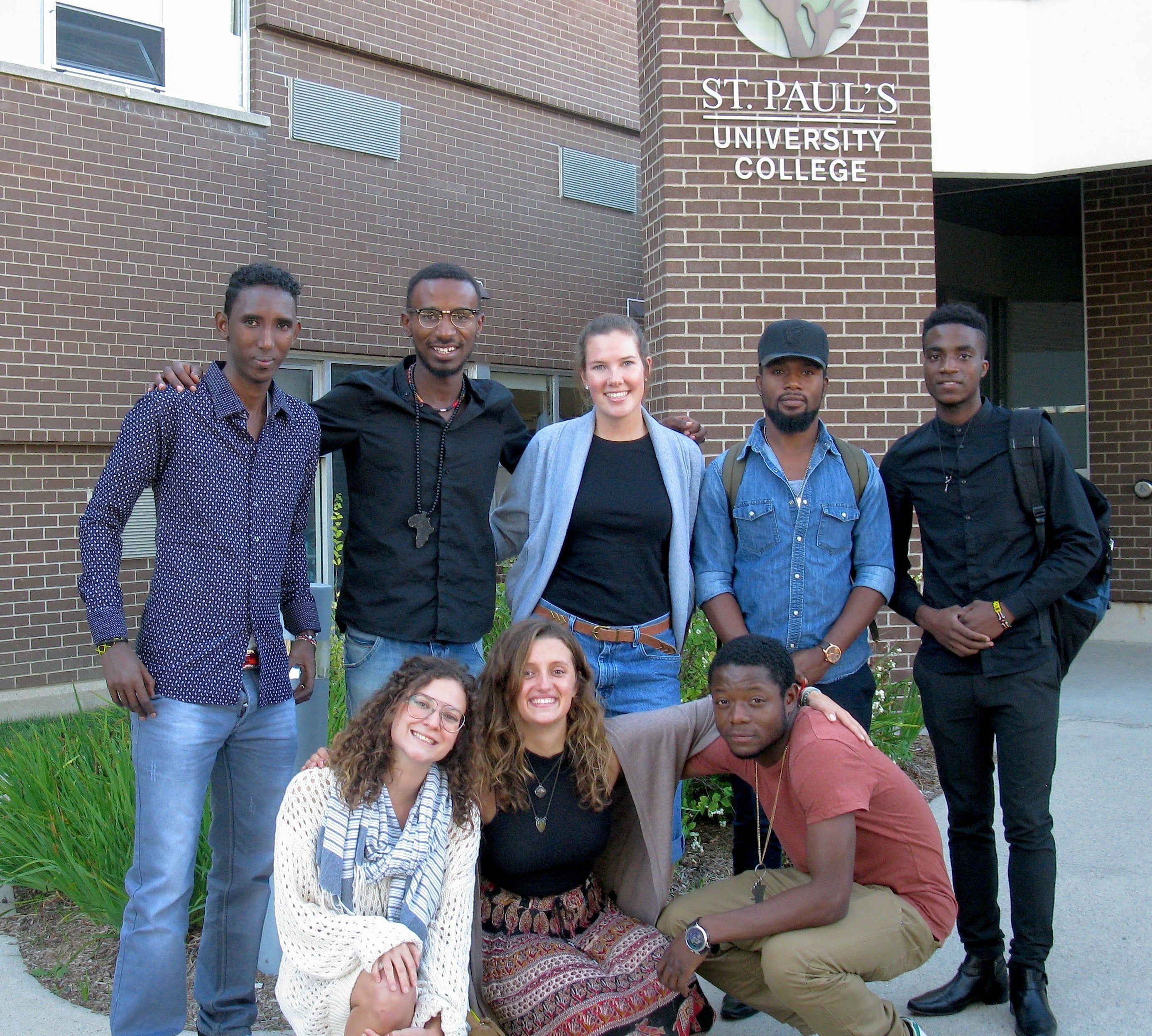 Members of the local WUSC committee with Leonard (bottom row, far right) and Liban (top row, far left).