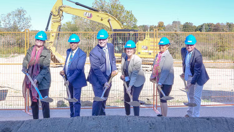 University of Waterloo and government representatives wear hard hats and heft shovels at the groundbreaking.
