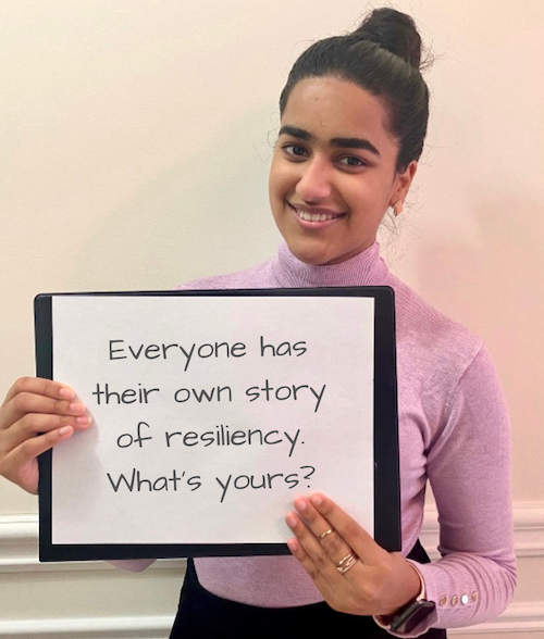 Student Bakhtawar Khan holds a sign that says "everyone has their own story of resilience. What's yours?"