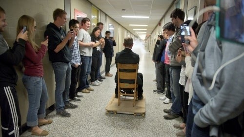 Chris Hadfield uses a fire extinguisher as a rocket in a physics building hallway.