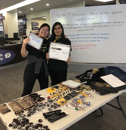Volunteers staff a booth in support of the International Day Against Contract Cheating.