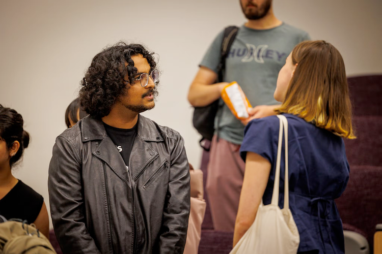 Attendees converse with one another at a networking event.