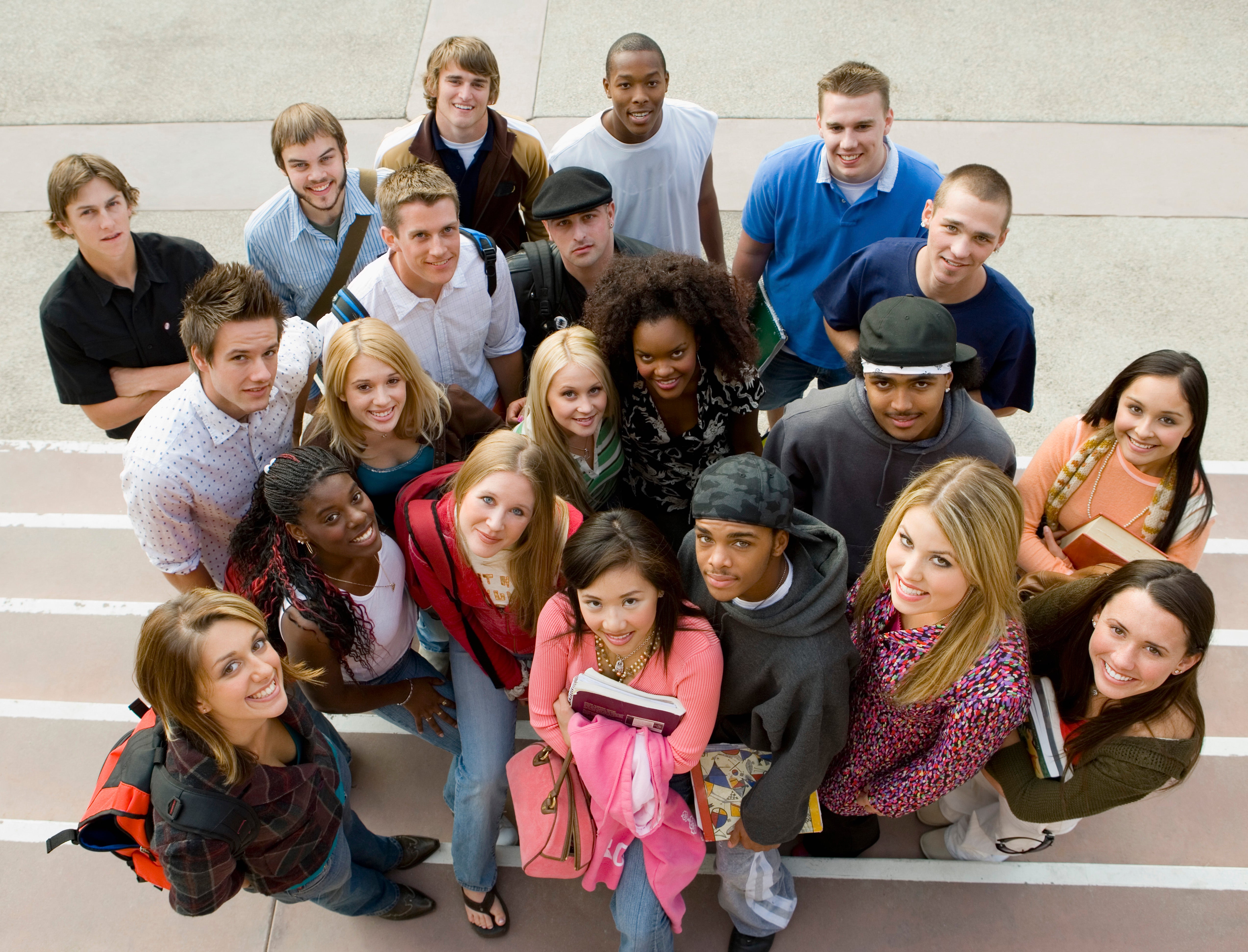 A diverse group of students looking up and smiling.