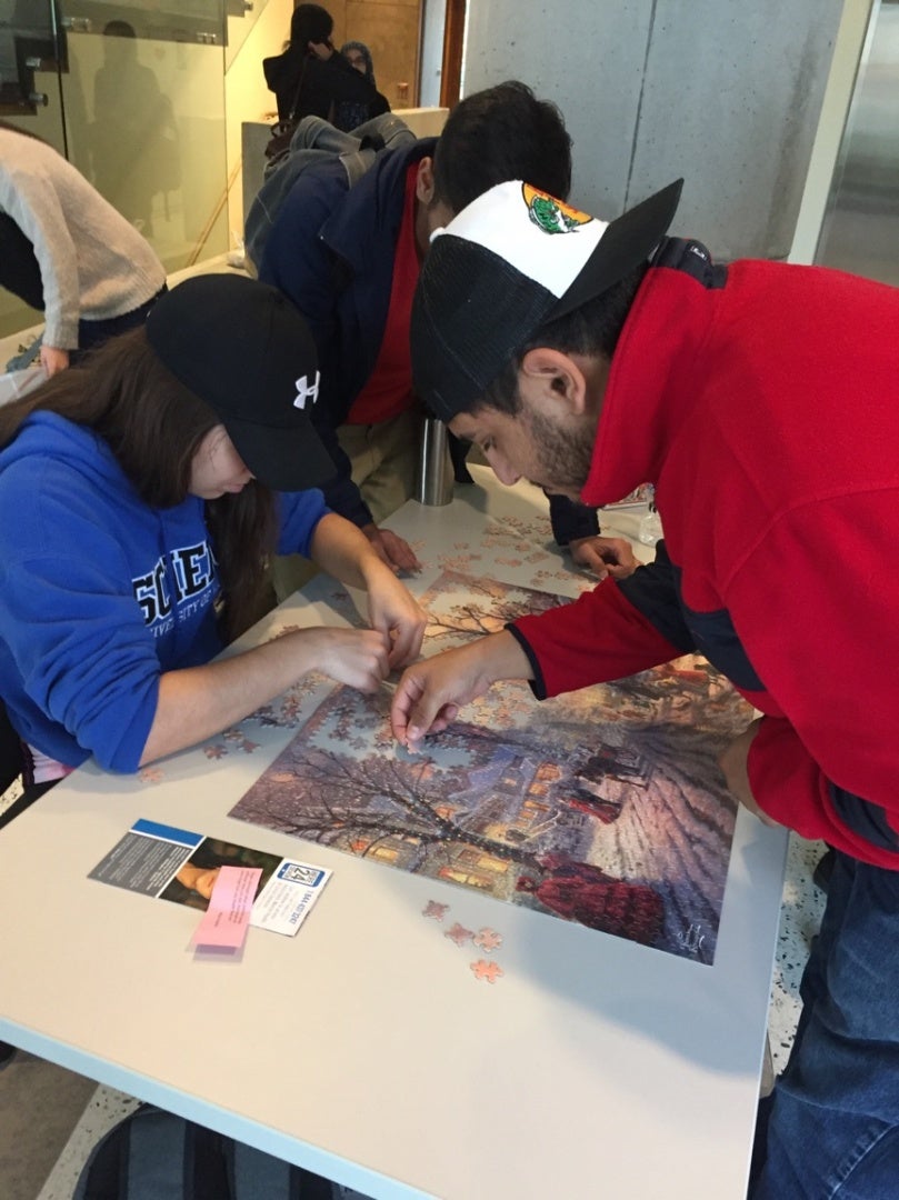 Two people work on a puzzle.