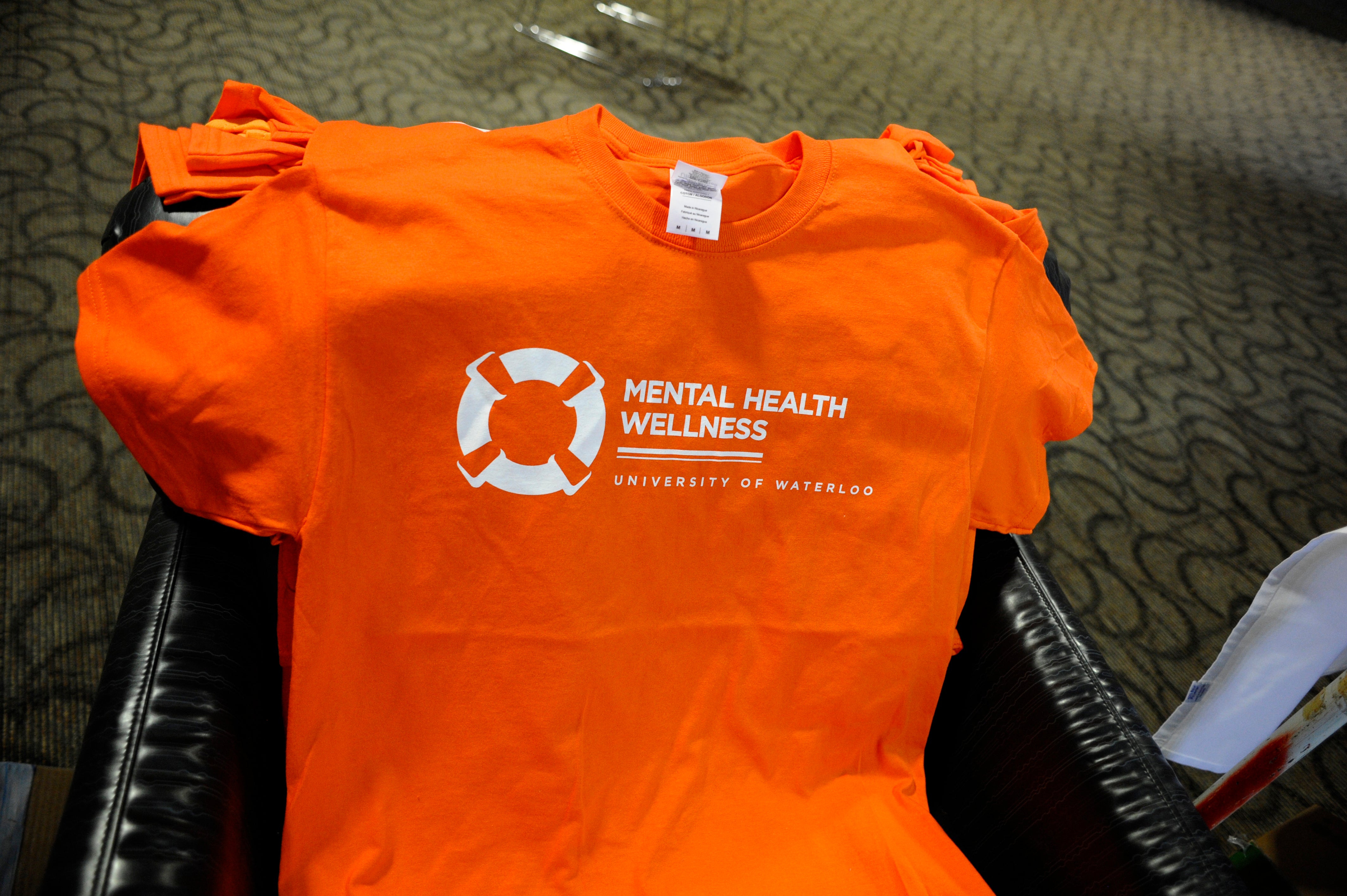 A basket of orange Mental Health Wellness Day shirts.
