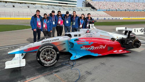 Waterloo teammates (l-r) Connor Kirby, Jatin Mehta, Ryan Larkin, Vivek Bhardwaj, Andre Slavescu, Brian Mao, Evelyn Campbell and John Liu pose with their self-driving race car at the Las Vegas Motor Speedway.