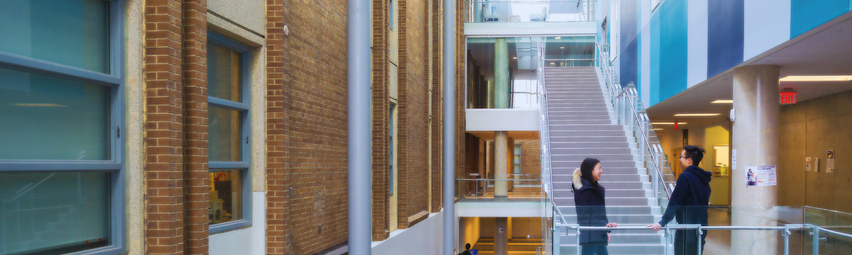 A man and woman converse on a stairwell landing in Environment 3.