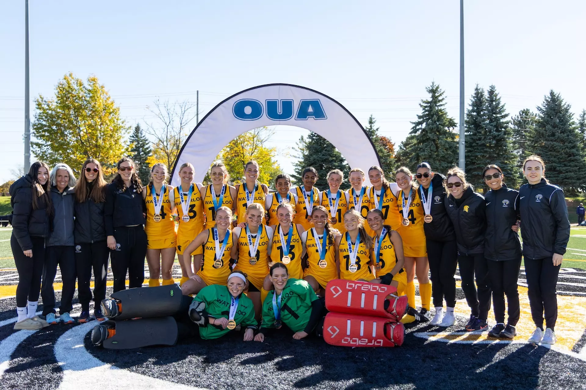 The Warriors women's field hockey team with the OUA banner.