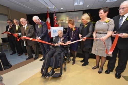 Delegates cut the ceremonial red ribbon at the Schlegel-UW research institute.