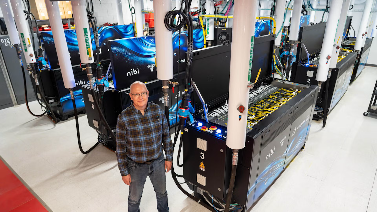 John Morton stands before the Nibi supercomputer setup.