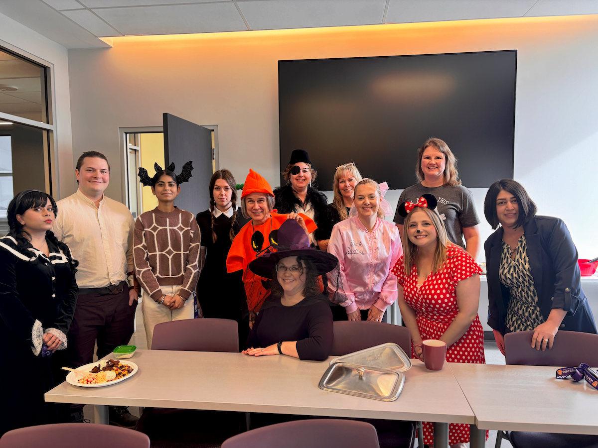 Systems Design Engineering faculty and staff in costumes at a potluck.