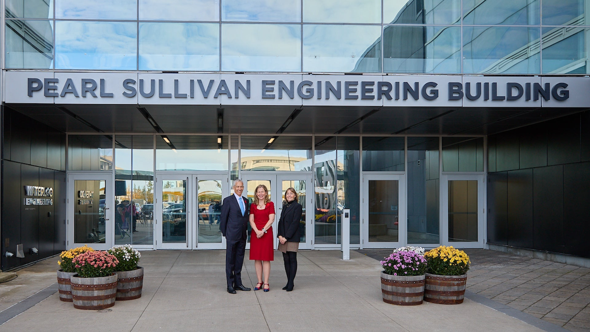 Frank Baylis, Dean Mary Wells, and Valerie Baylis stand in front of the new Pearl Sullivan Engineering Building sign.