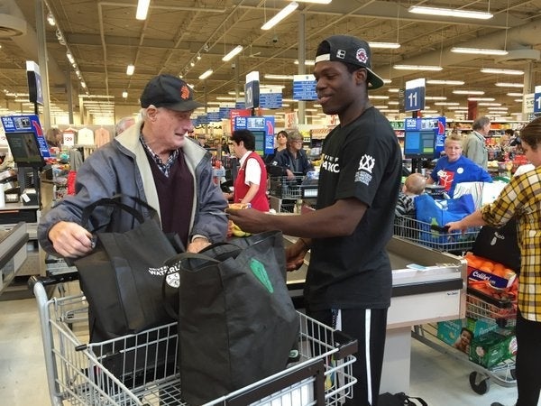 Random Act of Kindness Day volunteers bag groceries.