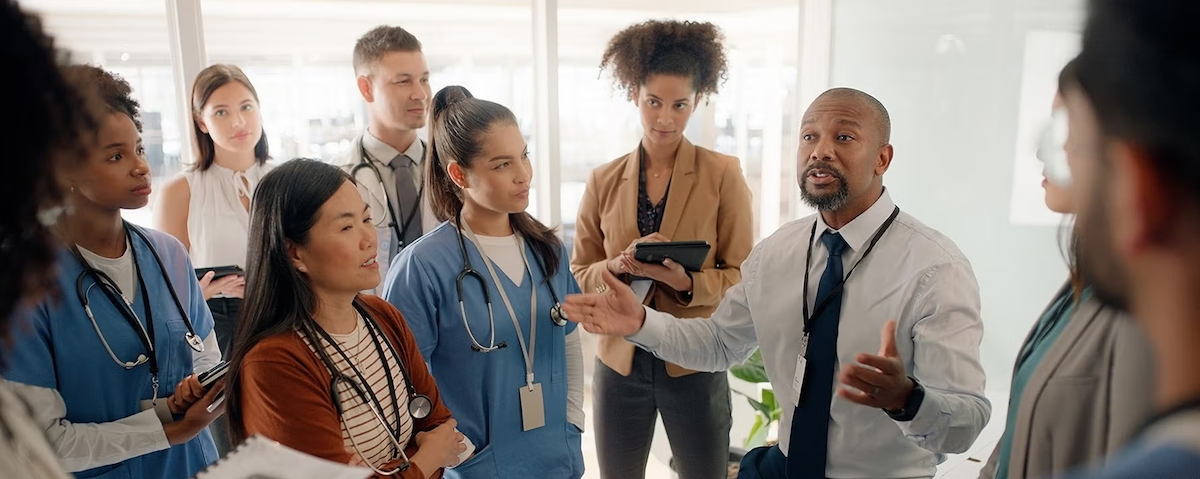 Health professionals converse in a hallway.