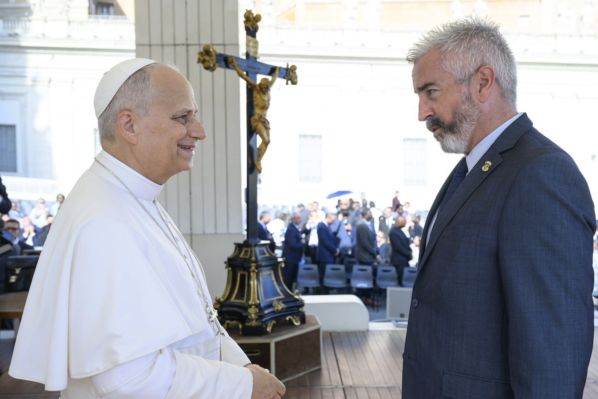 SJU President Peter Meehan meets Pope Leo XIV with a crucifix in the background.