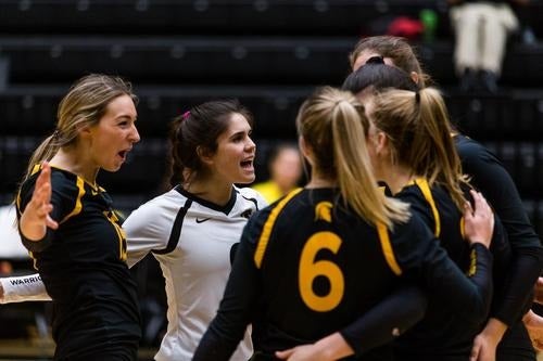 The women's volleyball team celebrates during a game.