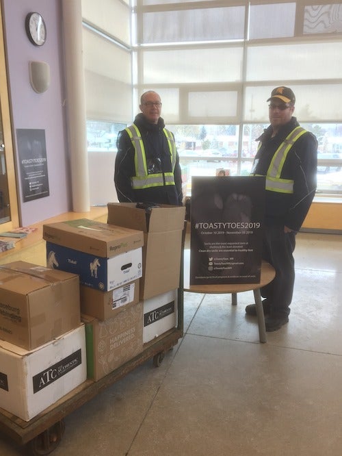 Central Stores staff members with the collected socks on a pallet.