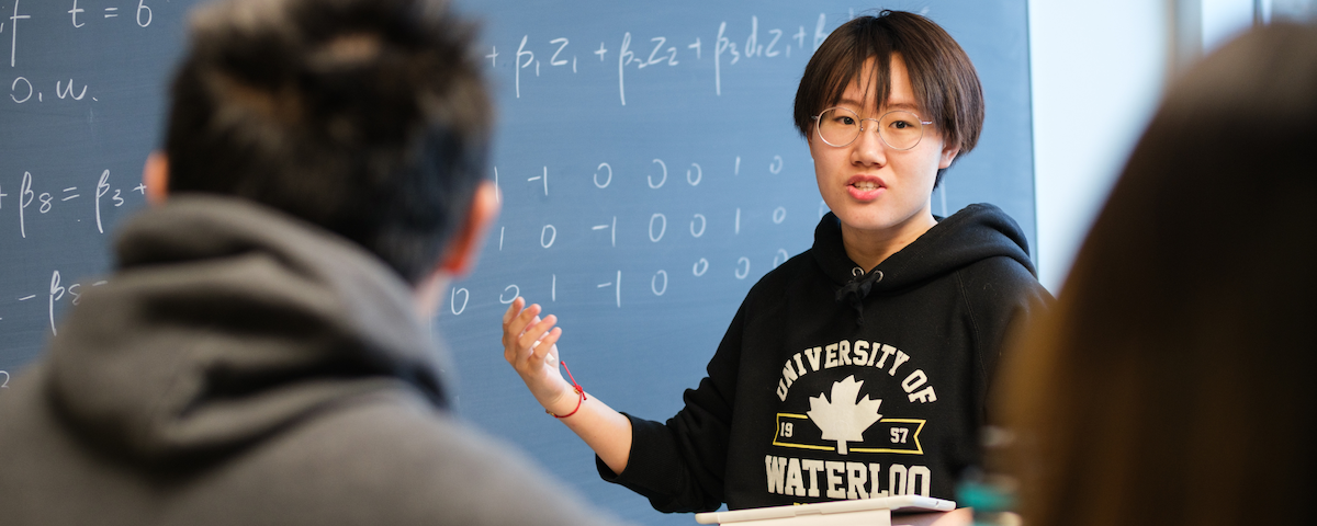 Student teaching in front of a chalkboard