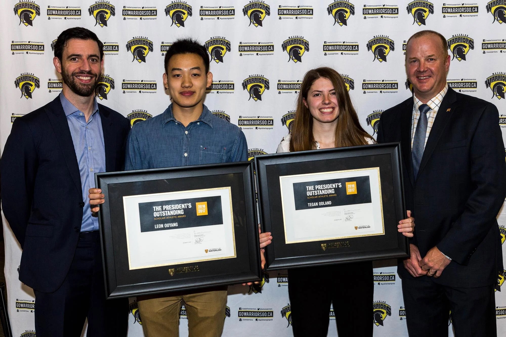 Leon Ouyang and Tegan Odland stand with Athletics representatives.