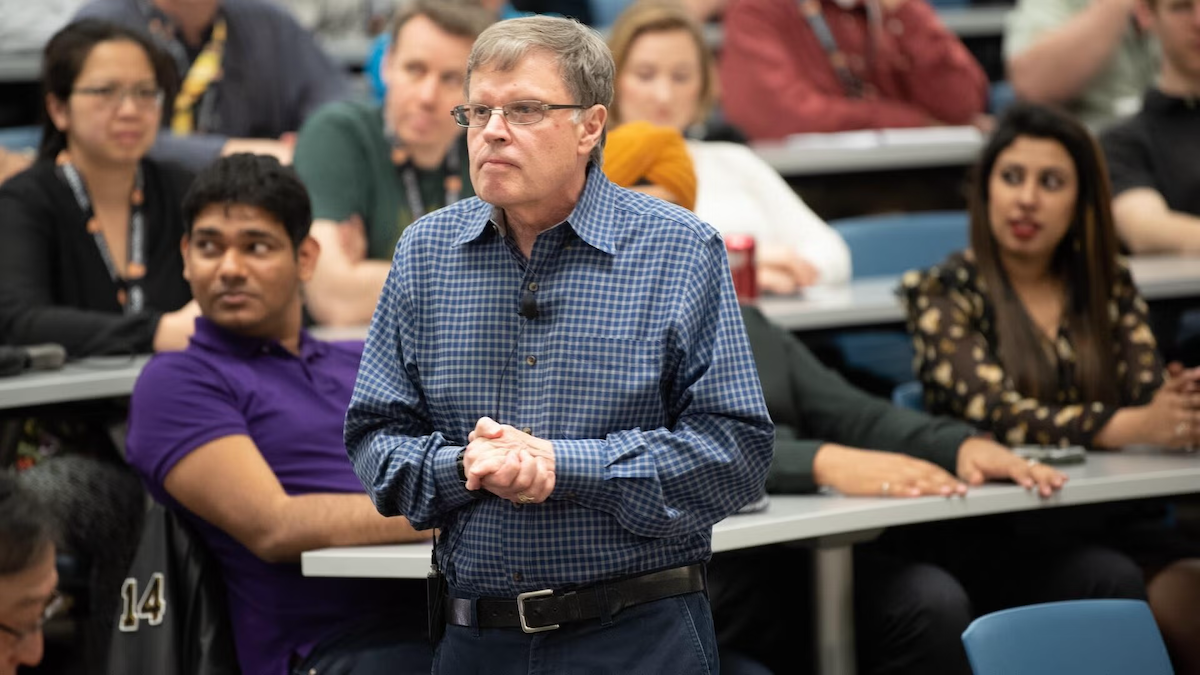 Larry Smith lecturing in front of students.
