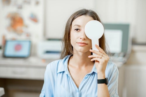 A woman uses a device to cover up one eye.
