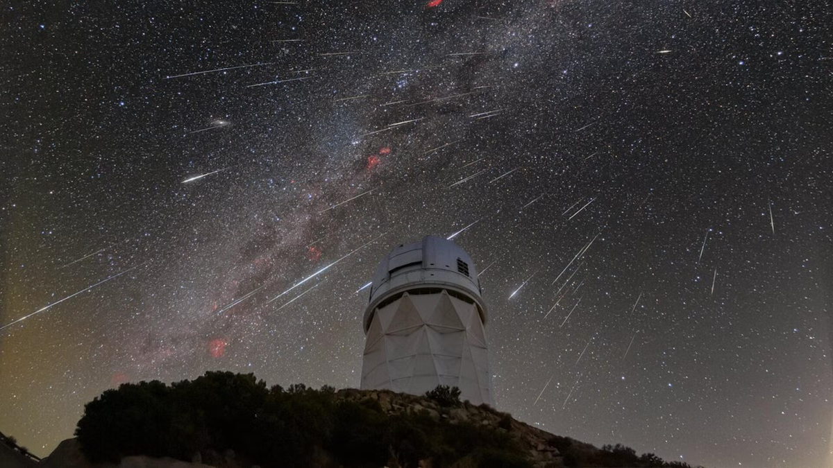 The Milky Way and meteors provides a backdrop for the DESI telescope tower atop Kitt's Peak.