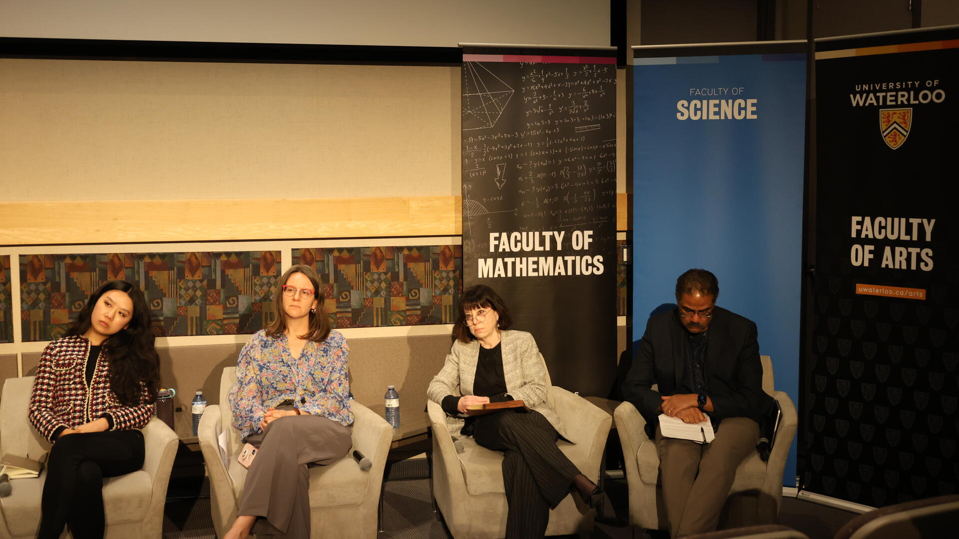 Speaker Series panelists seated on stage listening to a question from the audience.