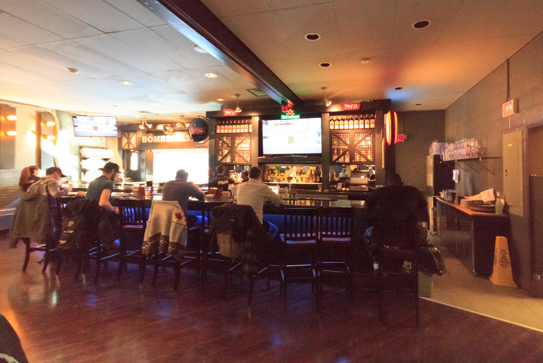 Patrons sit at the bar at the Bombshelter Pub.