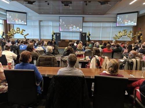 Attendees at the Nobel Prize viewing party settle in to watch the ceremony.