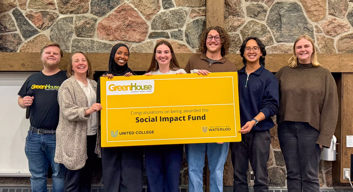 A group of people hold an oversized cheque.