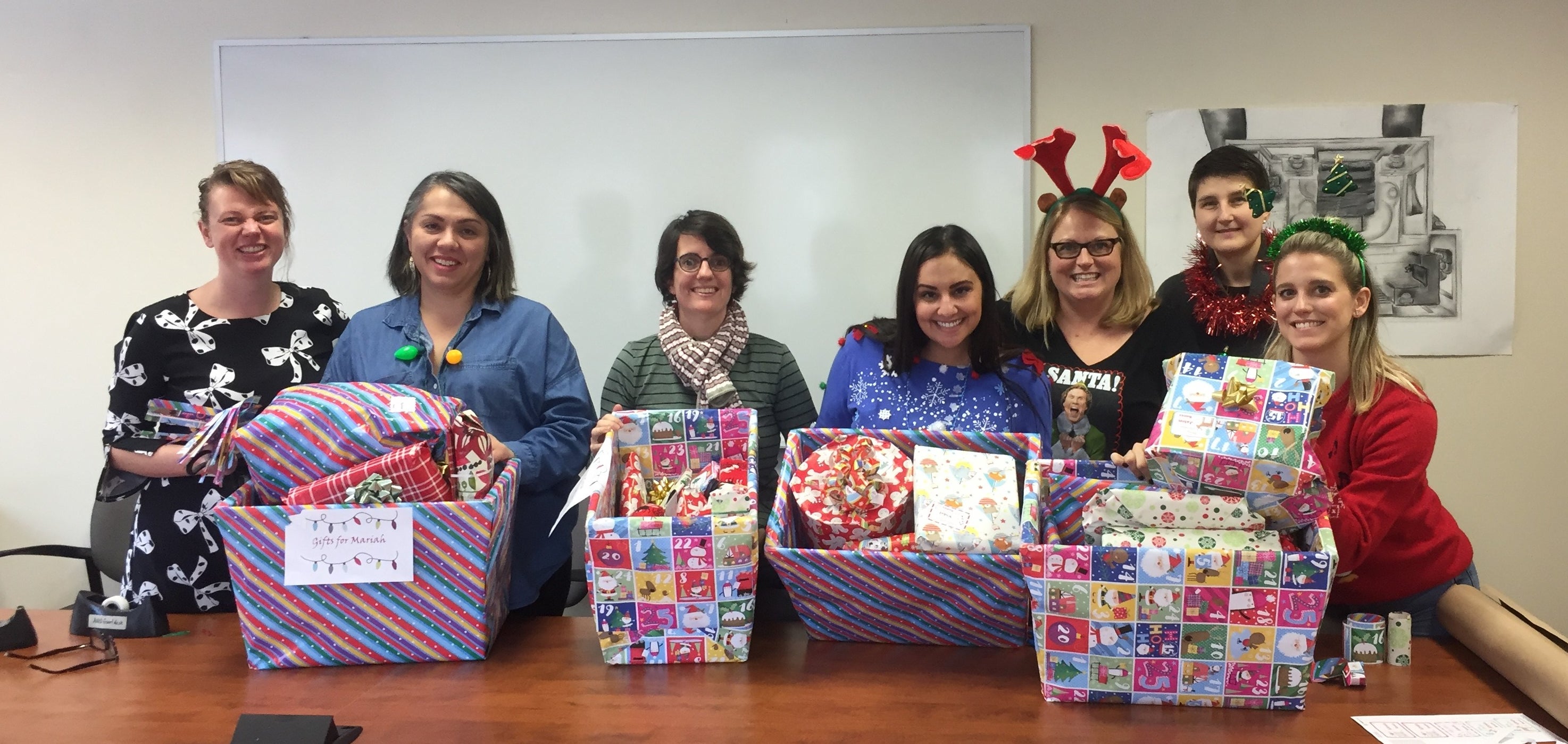 Staff from the Arts Undergraduate Office wrapping gifts for a sponsor family this Christmas.