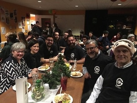 Feridun Hamdullahpur and members of his office staff at the Grad House for Free Food Thursday.